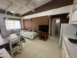 a kitchen and a living room with a bed and a refrigerator at M&M Cipolletti in Cipolletti