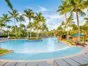 a swimming pool with palm trees in a resort at Hyatt Vacation Club at Coconut Cove in Bonita Shores