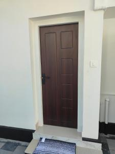 a wooden door with a mat in front of it at Ivory Suites in Kozhikode