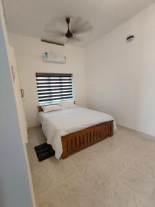a bedroom with a bed and a ceiling fan at Ivory Suites in Kozhikode