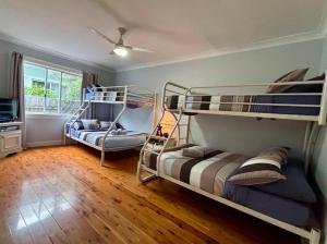 a room with two bunk beds and a tv at Watts @ Callala Beach-Pet Friendly in Callala Beach