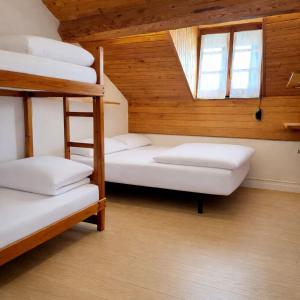 four bunk beds in a room with a window at Albergue Pájaro L in Castejón de Sos
