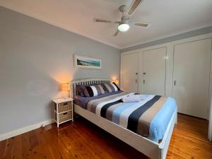 a bedroom with a bed and a ceiling fan at Watts @ Callala Beach-Pet Friendly in Callala Beach +17 photos