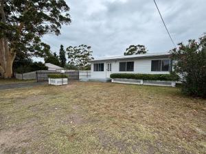 an empty yard in front of a white house at Watts @ Callala Beach-Pet Friendly in Callala Beach