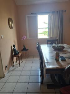 a dining room with a table and a window at bienvenue a la maison in Sainte-Marie +8 photos