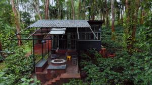 a tree house in the middle of a forest at Cove by Raho - Nestled Away Retreat in Siddapur