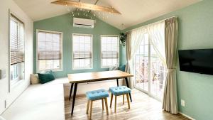 a dining room with a table and chairs and windows at Solana木更津 in Kisarazu
