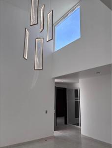 a white room with a window and pictures on the wall at Departamento lao in Santa Cruz