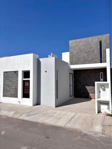a white building with a sign in front of it at Departamento lao in Santa Cruz