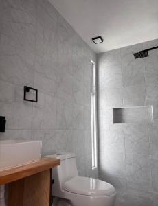 a white bathroom with a toilet and a shower at Departamento lao in Santa Cruz