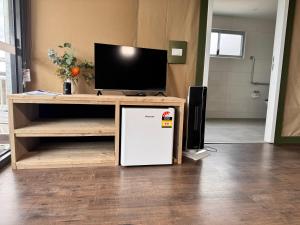 a small refrigerator under a table with a tv on it at Apollo Bay Recreation Reserve in Apollo Bay