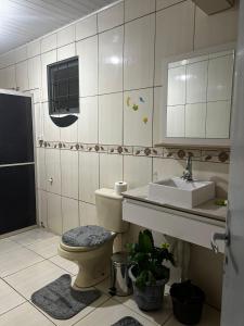 a bathroom with a toilet and a sink at Drica Pousada in São Gabriel +13 photos