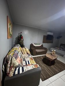 a living room with a couch and a christmas tree at Drica Pousada in São Gabriel