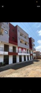 a large apartment building with red and white at Shanvinhomes -1 bedroom Apartment in Skuta-Nyeri Town in Nyeri