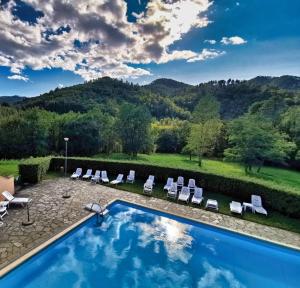 a swimming pool with lounge chairs and a mountain at Casa Melabruna, 5 terre biker friendly in Pignone
