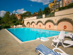 a swimming pool with two lawn chairs and two lawn chairs at Casa Melabruna, 5 terre biker friendly in Pignone +18 photos