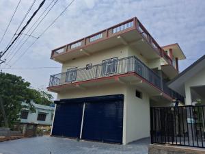 a house with a blue garage door with a balcony at AP'S Homestay Nilambur in Nilambūr
