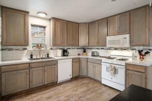 a kitchen with wooden cabinets and white appliances at Cherry Street Star in Bandera