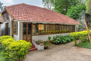 a small house with a red roof at The Anexure - Great Estate Stay for Remote Work in Siddapur
