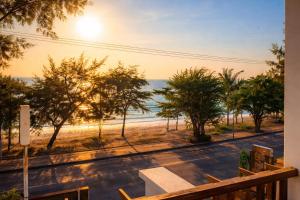 a view of the beach at sunset from a balcony at แอเรียวา พูลวิลล่า ชะอำ Areava Pool Villa Cha am in Cha Am