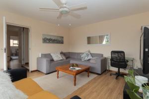 a living room with a couch and a table at Hartenbos Tranquility in Mossel Bay