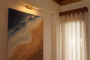 a painting hanging on a wall next to a window at Hermosa casita frente al mar en San Jose - Olon in San José