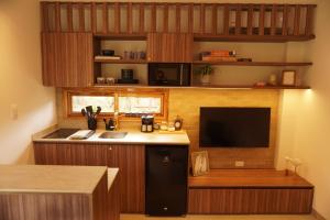 a kitchen with a sink and a tv in a room at Hermosa casita frente al mar en San Jose - Olon in San José