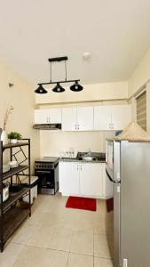 a kitchen with white cabinets and a stainless steel refrigerator at THE PRECIOUS TIME LOUNGe in Davao City +17 photos
