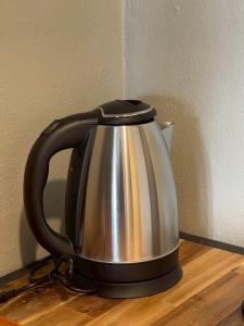 a black and silver tea kettle on a wooden table at Amazing Inn Koh Phangan in Thong Sala
