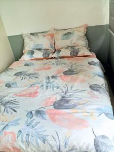 a bed with a floral comforter and two pillows at Haute Haven - 1br with Balcony in Manila +23 photos