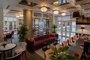 a living room with a couch and tables and chairs at Hotel Royal Hoi An Danang, The Legacy Riverfront Resort & Spa in Hoi An