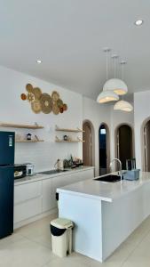 a white kitchen with a sink and a refrigerator at Beach Villas Phan Thiêt in Bình Sum