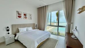 a bedroom with a bed and a large window at Beach Villas Phan Thiêt in Bình Sum +52 photos