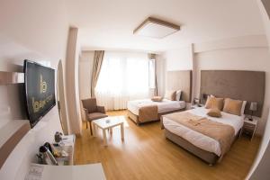 ein Hotelzimmer mit 2 Betten und einem Sofa in der Unterkunft Bilge Suite Hotel in Corum