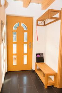 an orange door in a room with a bench at Brunarica Murka in Bohinj