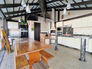 a large kitchen with a wooden table in it at Sobrado 4 quartos com piscina praia do tabuleiro in Barra Velha