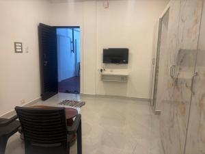 a living room with a table and a tv and a room at Eiffel Pondy in Pondicherry