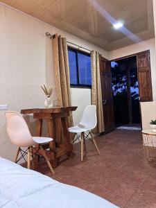 a bedroom with a bed and a table and chairs at Magic Lodge - Cirrí, Naranjo in Cirrí