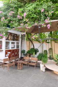 a patio with benches and tables and pink flowers at IN URBAN in Ho Chi Minh City