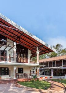an external view of a building with a large roof at Kumberi Manor by Raho - Heritage Retreat in Coorg in Ammatti