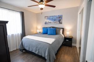 a bedroom with a bed with blue pillows and a ceiling fan at Aunt Beans Guest Suite in Kanab