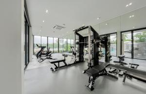 a gym with treadmills and elliptical machines and windows at Mont Du Kwai Resort in Ban Yang (2)