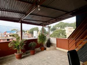 a balcony with potted plants on a roof at The Abode in Kathmandu