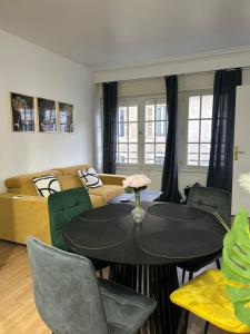 a living room with a table and a couch at L Écrin d or in Montluçon