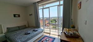 a bedroom with a bed and a large window at Rooftop View Home in Kampot