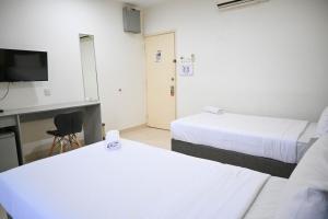 a hotel room with two beds and a television at Pusat Belia Antarabangsa in Kuala Lumpur +6 photos