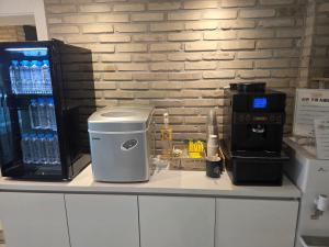 a coffee maker sitting on a counter next to a water bottle at DK hotel in Incheon