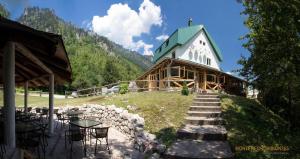 a large wooden building with a green roof at Hotel Ravnjak in Dobrilovina
