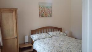 a bedroom with a bed and a painting on the wall at The Snicketts in Ludlow