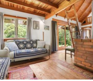 a living room with a couch and some windows at The Innlet, Country Apartments and Cottages in Collingwood
